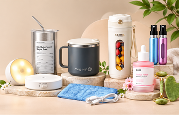 A styled product lineup on a warm beige surface featuring a stainless steel travel mug with a straw, a dark gray insulated tumbler, a white travel bottle with a colorful fruit window, two small colorful bottles, skincare bottles, a blue cloth, and small decorative props.