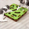 Two cats playing with a green and brown cat toy on a striped carpet.