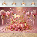 A festive New Year backdrop featuring pink hanging lanterns, gold decorative elements, large pink flowers, and the words 'Happy New Year' in gold lettering, set against a pink background with a wood floor visible at the bottom.
