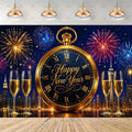 A New Year's Eve party backdrop or photography background featuring a large gold pocket watch with 'Happy New Year' text, fireworks in blue, red, and gold, a city skyline at night, and four champagne flutes on a wooden floor.
