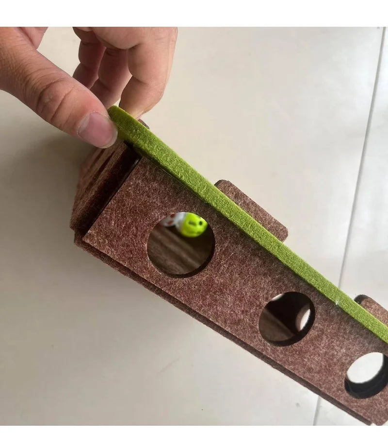 Hand holding a sanding block with green sandpaper on a white surface