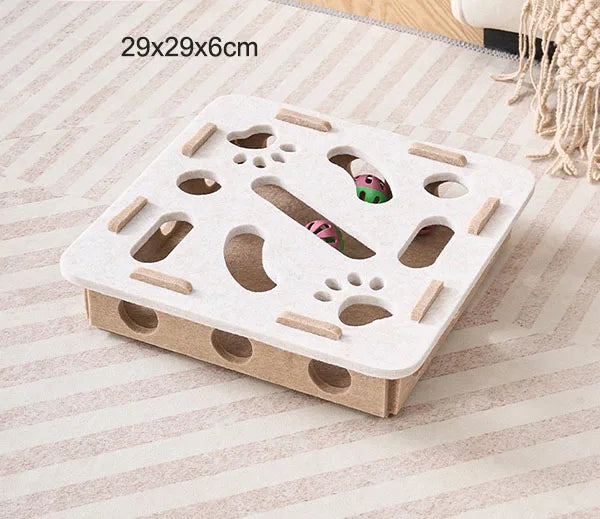 Cardboard cat toy with various holes and tunnels on a striped surface
