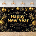 A festive New Year backdrop featuring a black background decorated with gold stars, ornaments, pine branches, and the words 'Happy New Year' in large gold lettering. The scene includes a light wood floor and hanging pendant lights above.