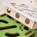 Pet toy with green base and beige top, featuring holes and textured surfaces.