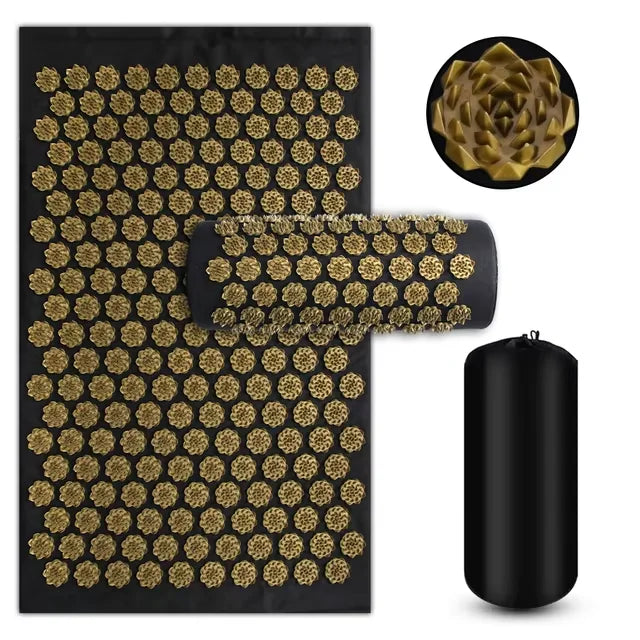 Acupressure mat with black and gold design, rolled up mat, and cylindrical black roller on a white background.