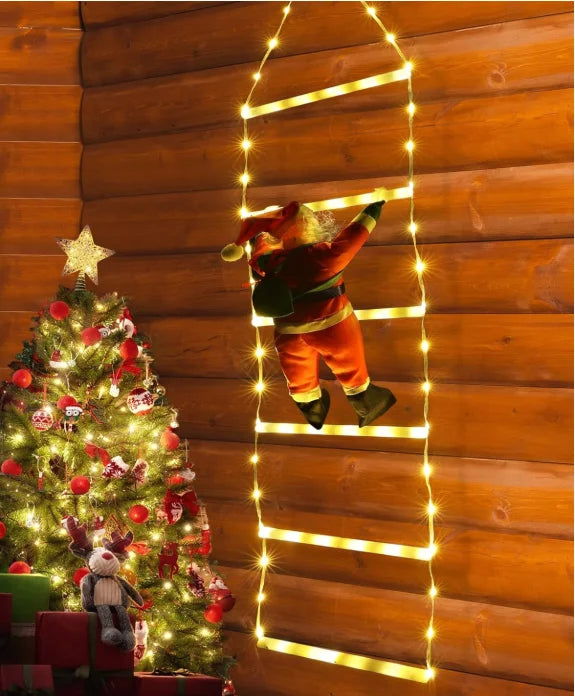 Decorative setup with a Christmas tree, Santa Claus figure, and string lights on a wooden wall.