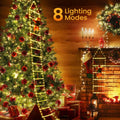 Decorated Christmas tree with lights and fireplace in a cozy room.