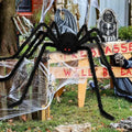 Halloween decoration with a large spider and tombstones on a wooden platform.