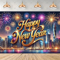 A New Year's Eve party backdrop banner featuring a vibrant city skyline at night with colorful fireworks exploding in the sky. The text 'Happy New Year' is written in a large, metallic gold cursive font in the center.
