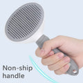 Gray handheld shower head held by a hand with a light blue background