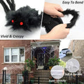 Black furry creature with red eyes, being bent by a hand, and used as a Halloween decoration on a house exterior.