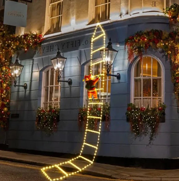 Decorative building facade with Christmas lights and a teddy bear figure.
