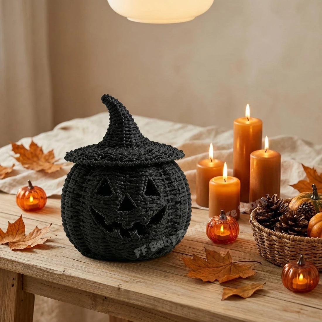 Three woven Halloween decorative items displayed together: a large black witch hat jack-o'-lantern lantern, a smaller orange jack-o'-lantern hanging lantern, and a black candy pot filled with colorful candies, set against a smoky nighttime outdoor scene with a ghost in the background.